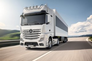 Mercedes Actros mit Anhänger fährt auf einer Strasse in den Bergen