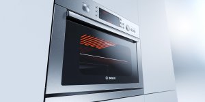 Bosch Einbauofen aus Edelstahl eingebaut in heller Küchenfront vor neutralem Hintergrund