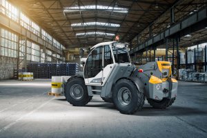 Liebherr Teleskoplader beladen mit Fässern und Europalette in Industriehalle